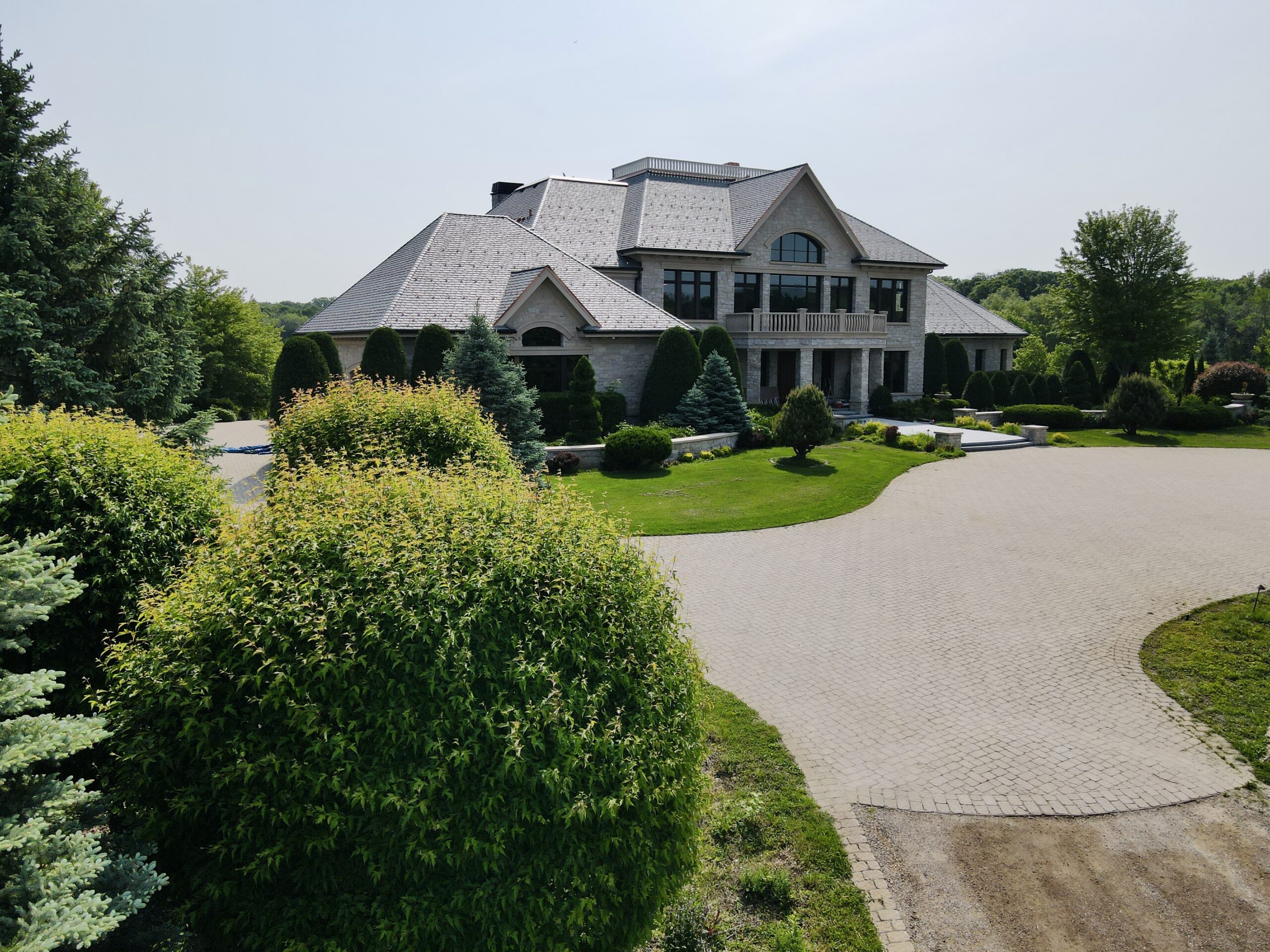 Grand entryway of a Minnetrista luxury estate featuring premium slate roofing and elegant landscaping.