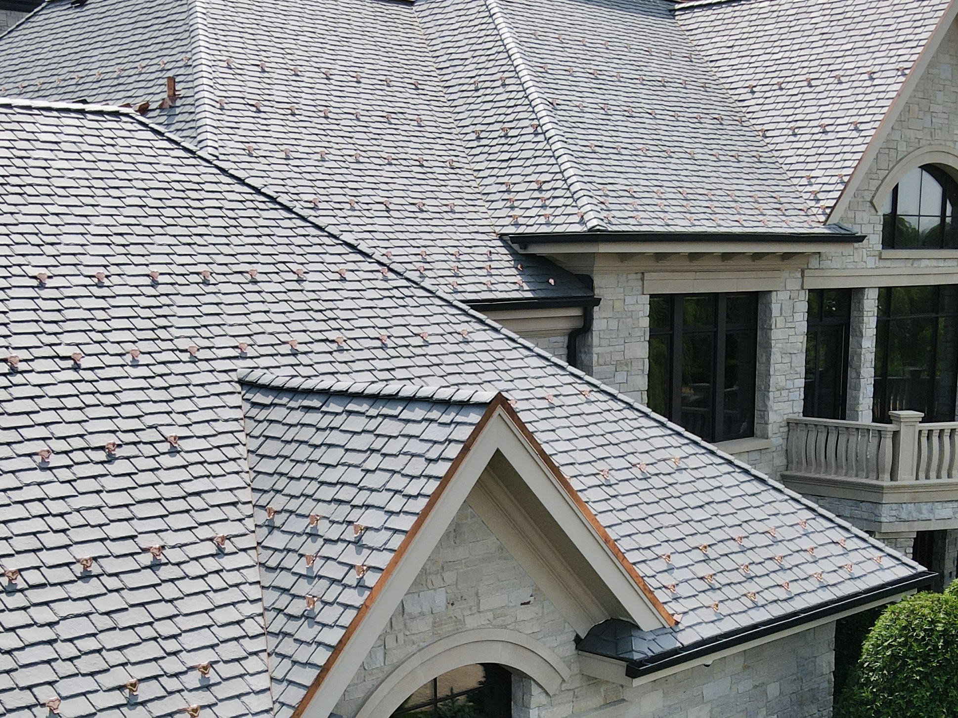 Close-up detail of premium slate roofing with copper snow guards on a luxury home in Minnetrista, MN.
