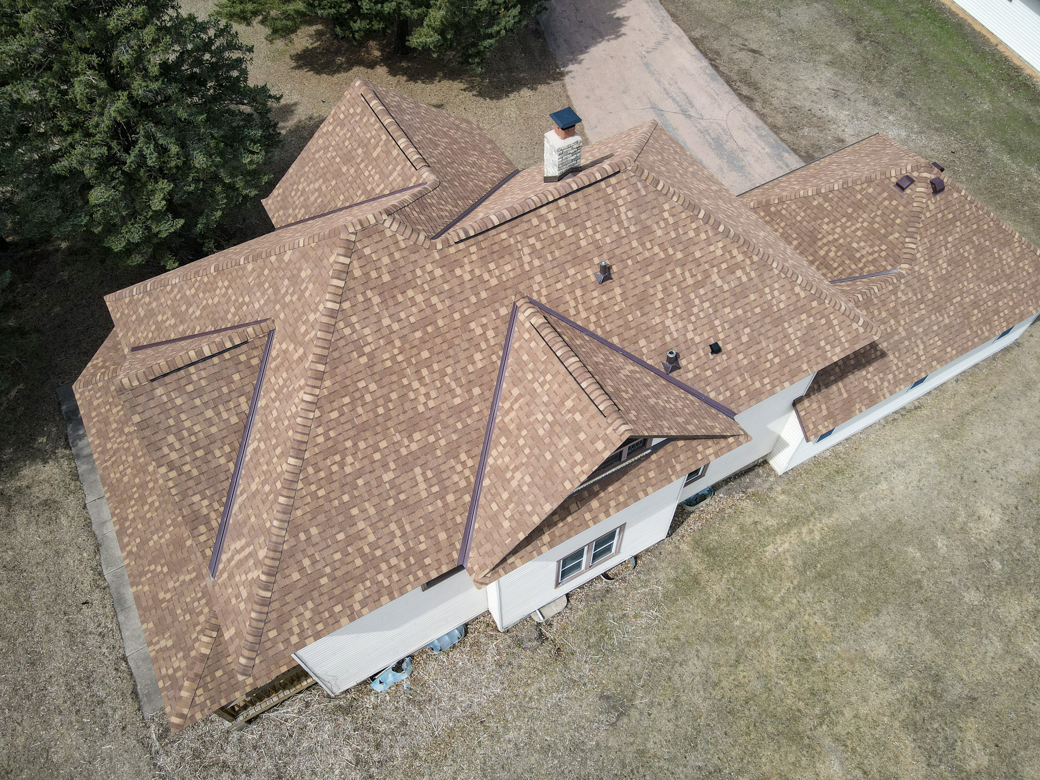 Aerial view of a residential home with a new asphalt shingle roof installed by Allied Construction