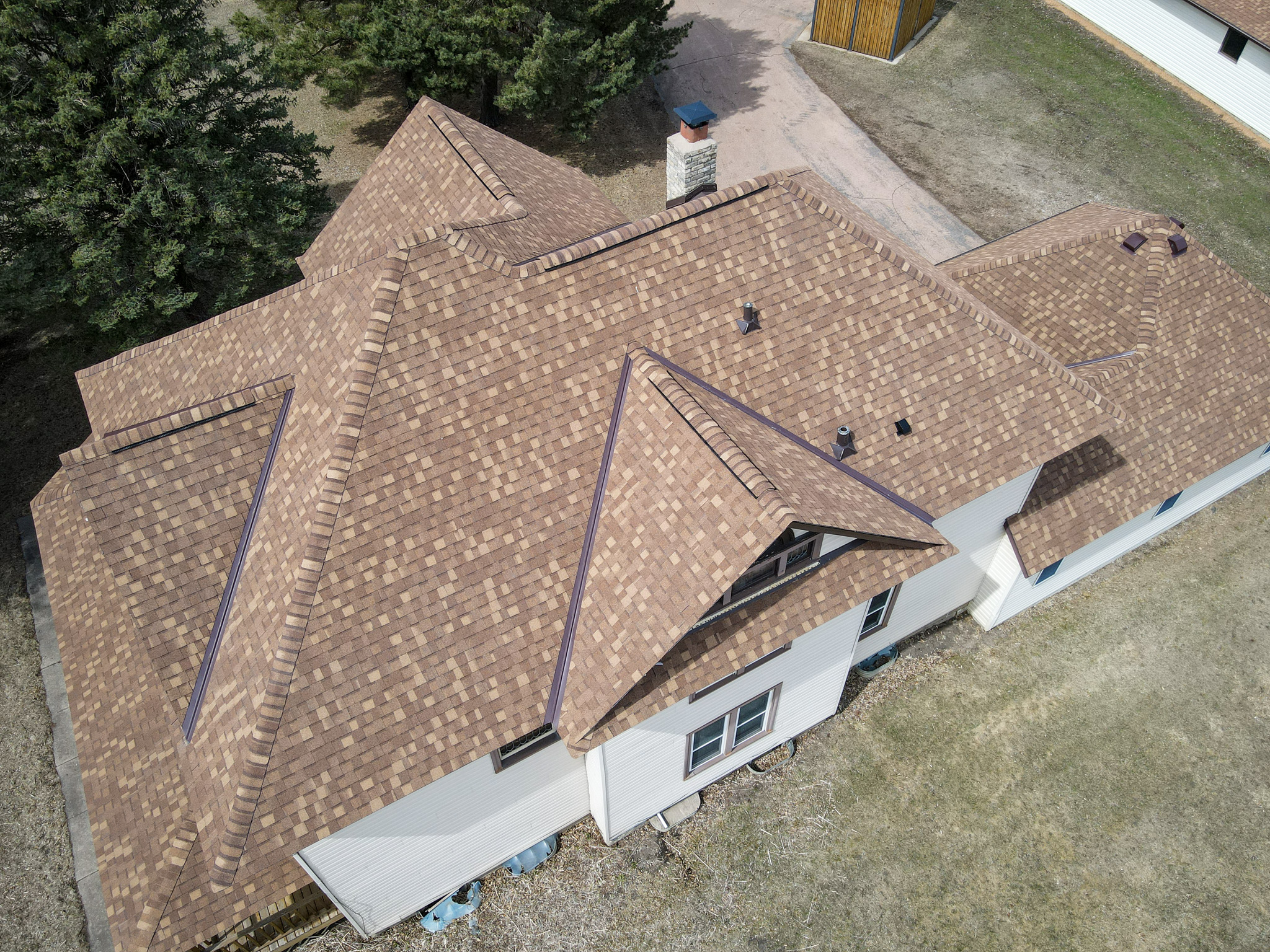Aerial photo of a newly installed brown asphalt shingle roof on a residential home by Allied Construction in Minnesota