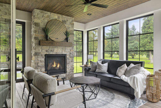 Sunroom with stone fireplace, window replacement, wood ceiling, and modern furniture