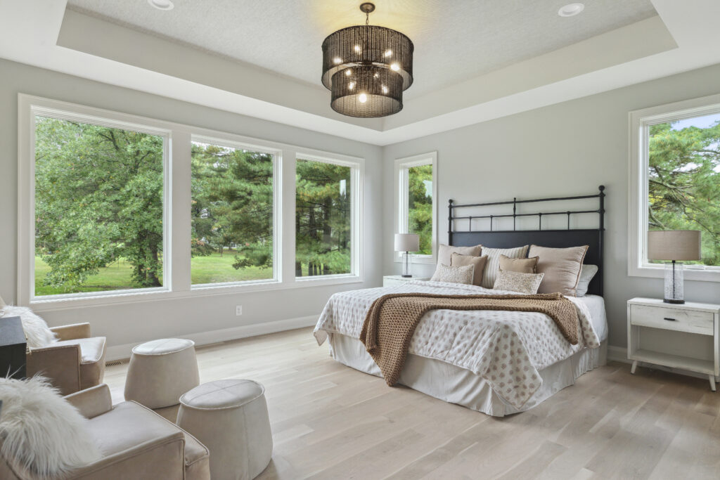 Bright bedroom with large windows and neutral tones