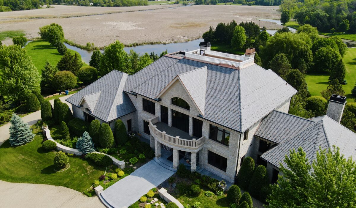 Stunning slate roof on a custom home in Minnetrista, MN, overlooking natural wetlands and lush greenery.