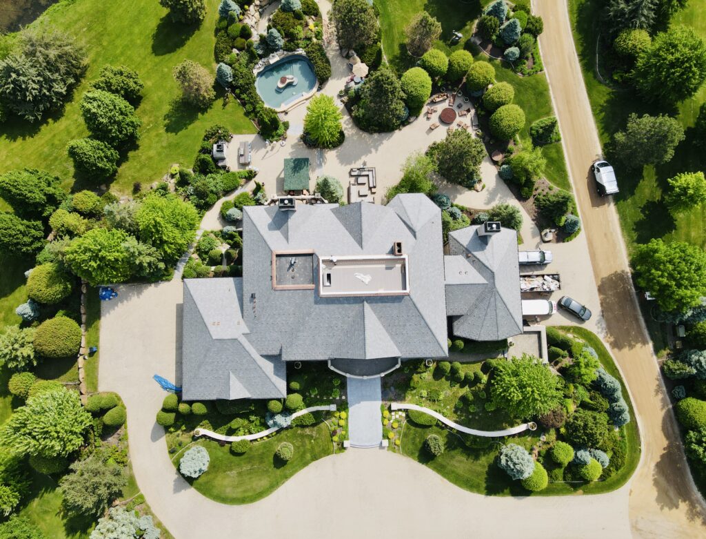 Aerial view of a luxury Minnetrista property with slate roofing, formal landscaping, and extensive outdoor amenities.