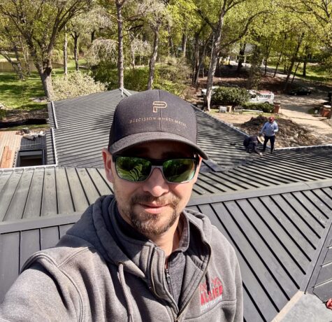 Allied Construction roofer standing on metal roof during installation