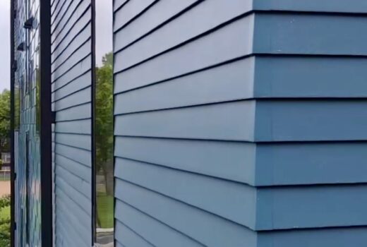 Close-up of modern blue siding installation at Bryant Ave Lofts in Minneapolis, MN.