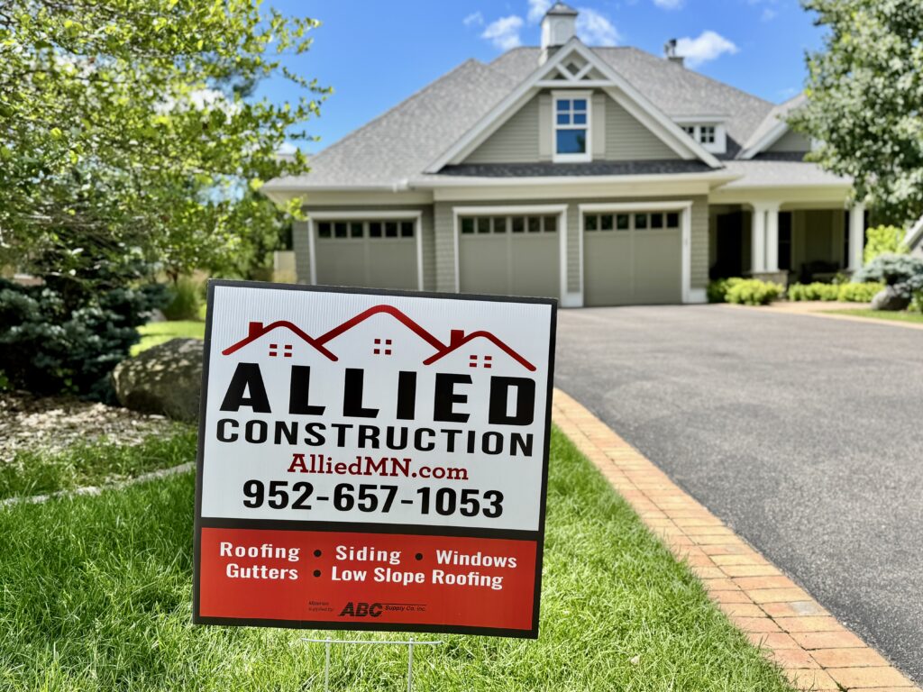 Allied Construction yard sign in front of a modern gray home with a well-kept lawn.